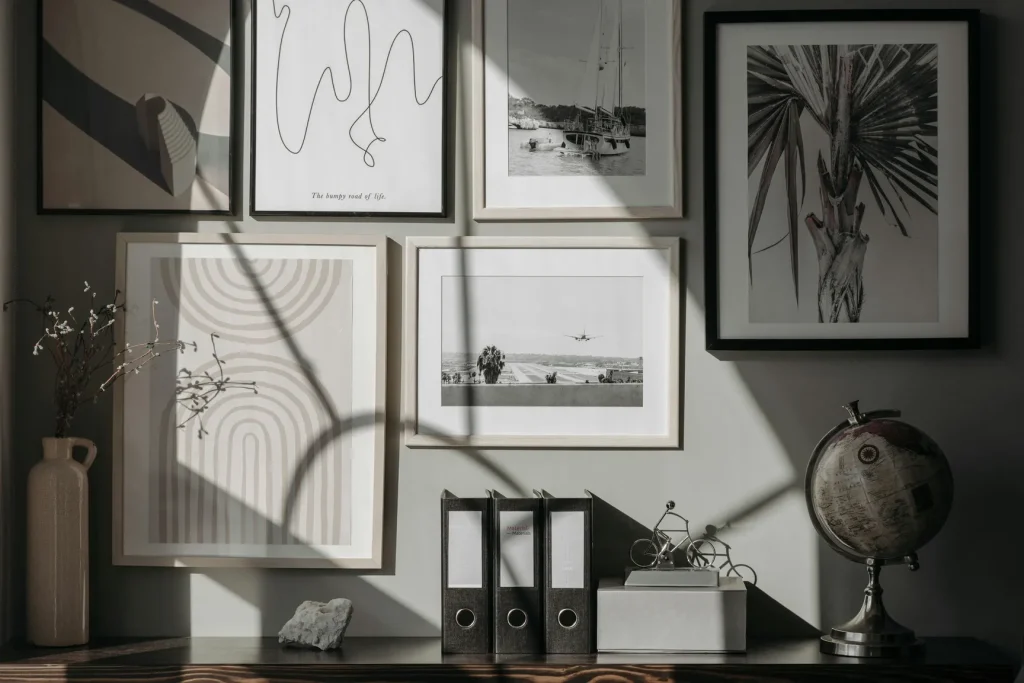 Gallery wall with mixed black and white prints and abstract art on a dark grey wall